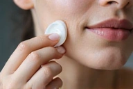 A gentle hand applying serum to a face